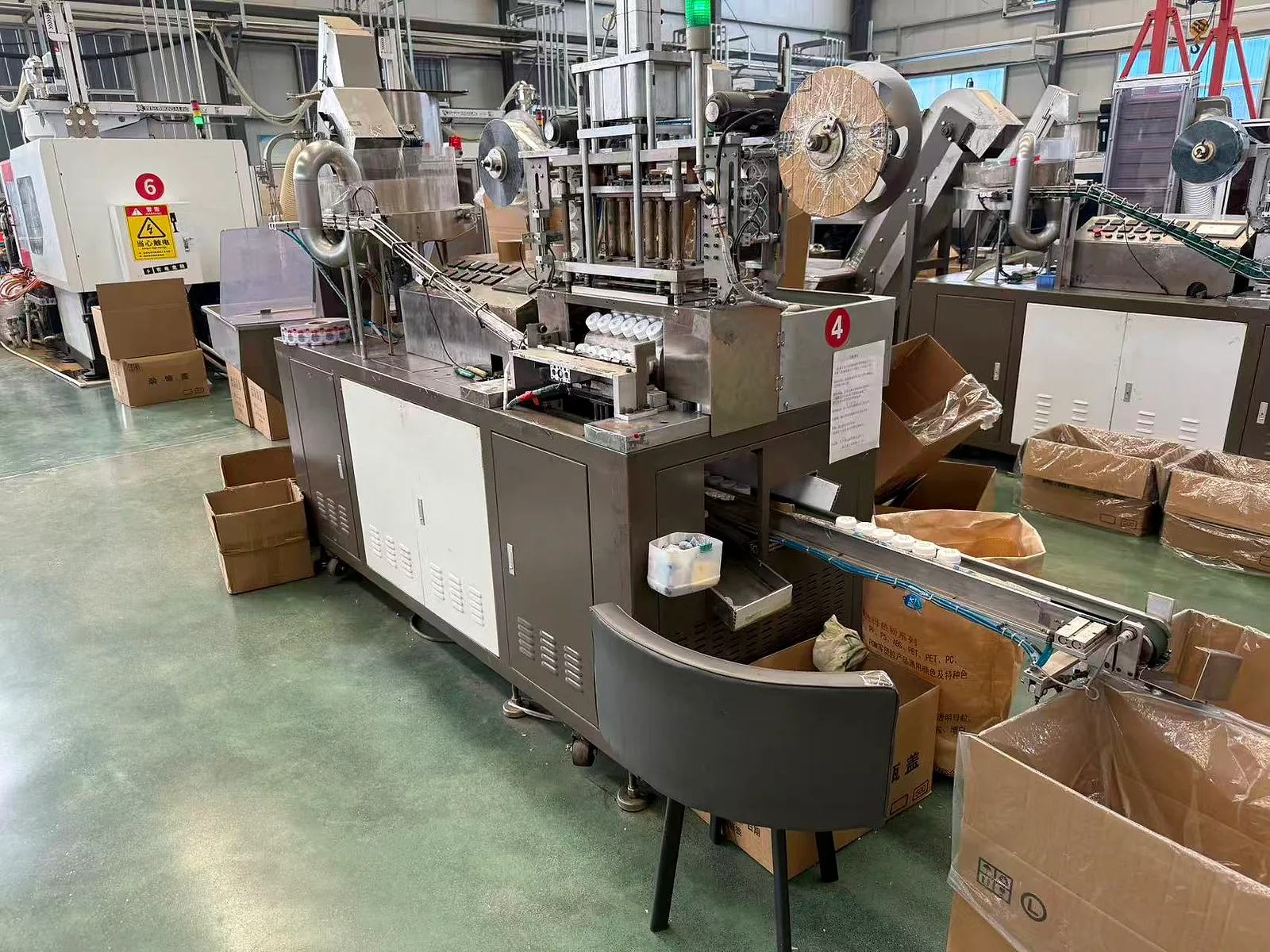 Automated cap finishing line with output conveyor feeding collection cartons